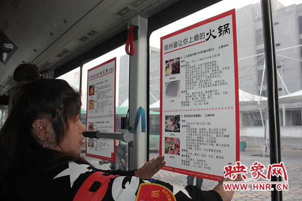 车长在车厢内张贴郑州美食宣传页