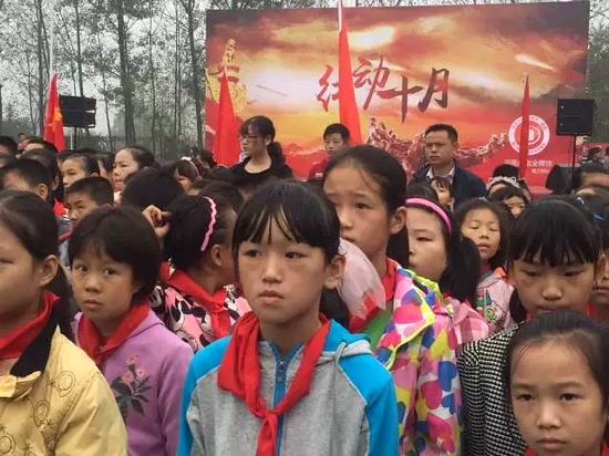 河南广电媒体的大朋友和信阳铁铺学校的小朋友们一起唱国歌