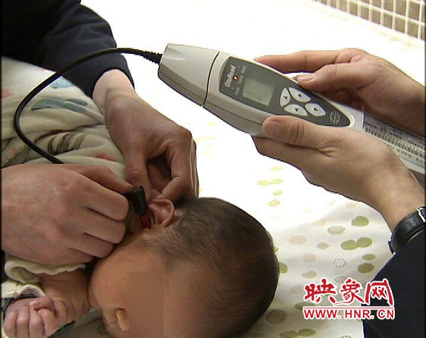 医护人员正在为一名新出生的小宝宝做听力筛查