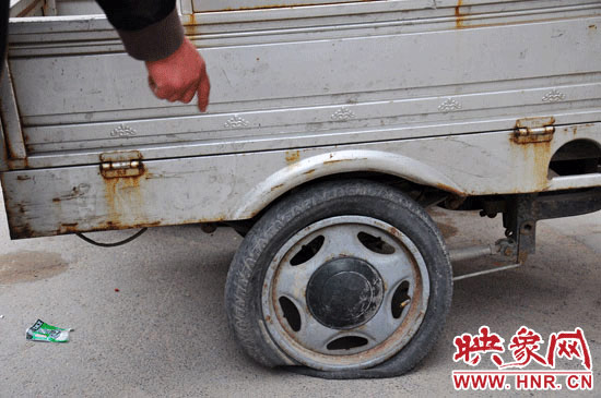 一辆电动三轮车的车胎被扎破 一辆电动三轮车的车胎被扎破