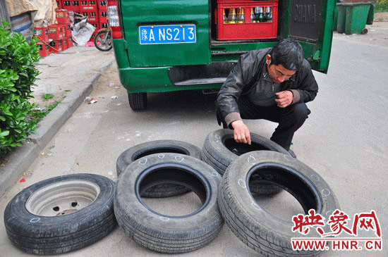 老杨在清点被扎破的轮胎-郑州一商户汽车轮胎频频被扎 原来是楼上老高清图片