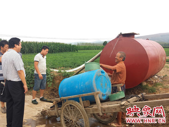 平顶山市宝丰县李庄乡马疙瘩村，村民们带着大小不一的储水容器在当地水利部门布设的水罐旁有序取水。