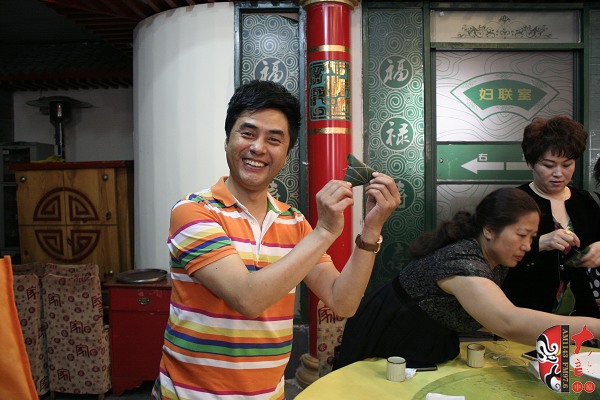 青年豫剧表演艺术家、第三代栓宝的扮演者盛红林展示他包的粽子
