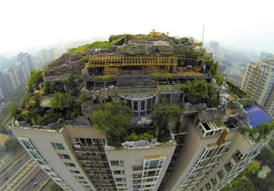 　　昨日，身穿橘黄色马甲的工作人员在人济山庄楼顶拆除违章建筑。新京报记者 吴江 摄