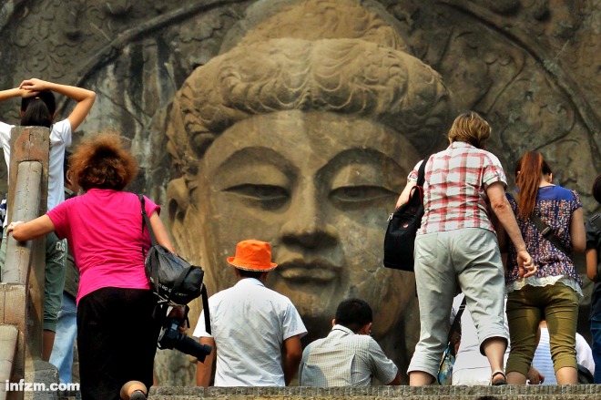2013年9月19日，几位游客沿石阶登上洛阳龙门石窟的奉先寺景区。当日是中秋小长假的第一天，全国各地