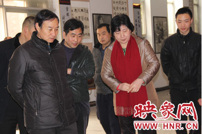 参加仪式的领导观看学生的艺术作品
