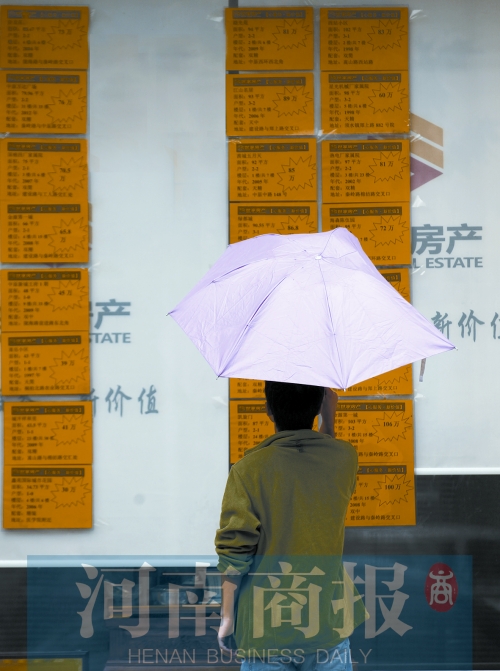 一位郑州市民正在看房屋中介公司挂出的房源标价