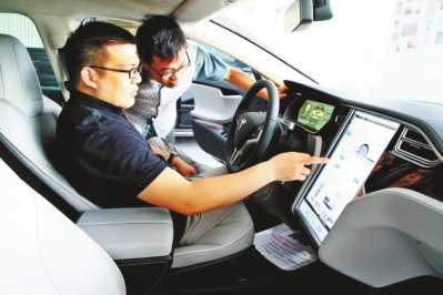 陈玉生坐驾驶座上为记者介绍特斯拉的触控屏