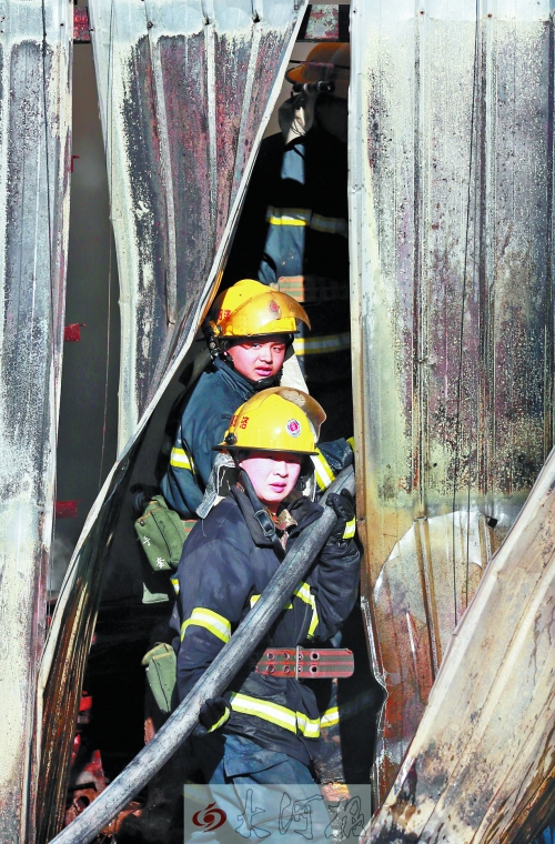 消防队员穿过铁皮房夹缝 消防队员穿过铁皮房夹缝