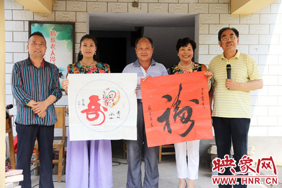 苏金昌(右一)向敬老院赠送代表“福寿康宁 ”的书法字画