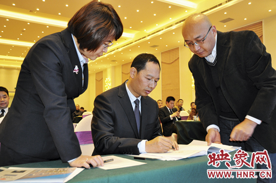 公司董事长李益民在大会通过的议案上签名 公司董事长李益民在大会通过的议案上签名