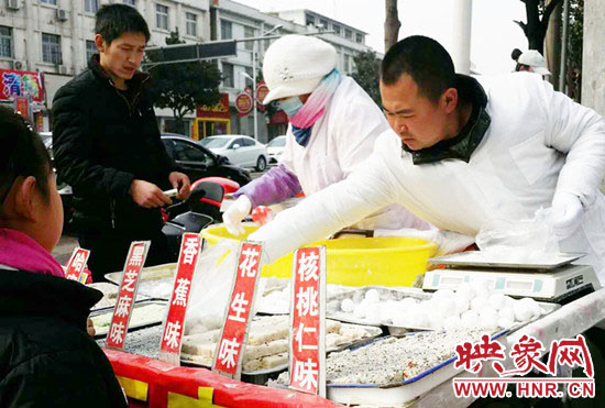 2月22日，在河南宝丰一家元宵加工店，工作人员在用元宵制作工具摇元宵。