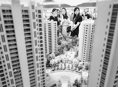 图为近日，浙江杭州一家房产公司的两位销售人员一起向购房者介绍楼盘。新华社记者 王定昶摄