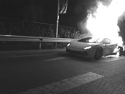 前晚9时许，东四环东风北桥附近，一辆白色兰博基尼跑车在路边自燃。微博网友 党david 摄