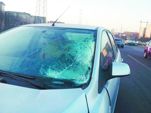 肇事轿车前挡风玻璃上，留着清晰的撞击痕迹。