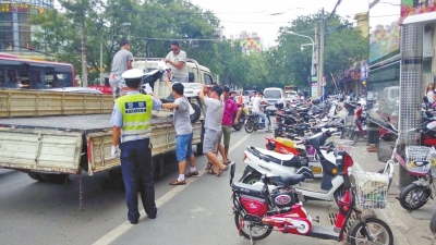 路旁的非机动车道已被多辆违法停放的电动车和自行车占满