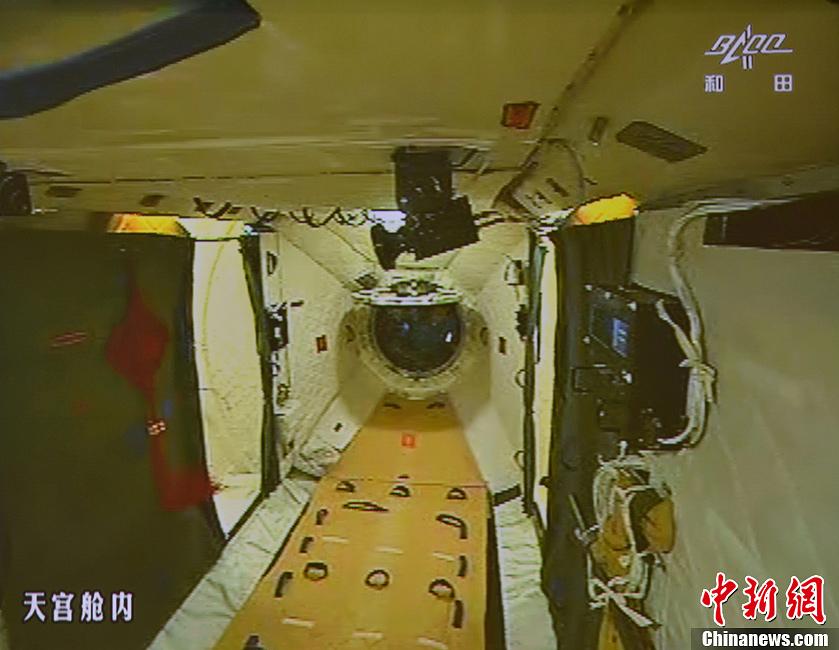 图为在张晓光的协助下，聂海胜顺利开启天宫一号舱门。