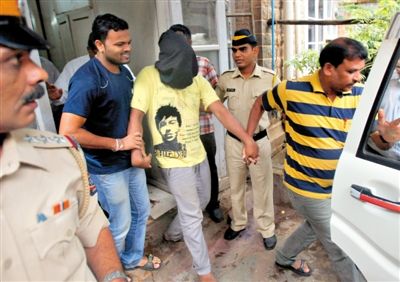 25日，孟买，警方押解着涉嫌性侵女记者的疑犯，疑犯头上套着黑布套。