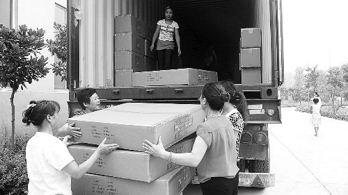 　山东泰安宝文斯服装厂，工人们正在往卡车上装货。