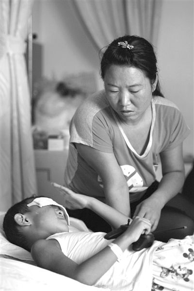 9月4日，山西省太原市眼科医院，小斌手握玩具。当日，小斌听到警方破案的消息立即躲在母亲的怀里。图/CFP