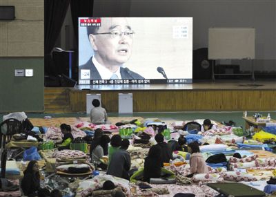 27日，韩国珍岛，“岁月”号客轮乘客家属在体育馆观看总理郑烘原辞职新闻。当日，郑烘原召开紧急发布会，表示对韩国“岁月”号沉船事件负责，宣布引咎辞职。