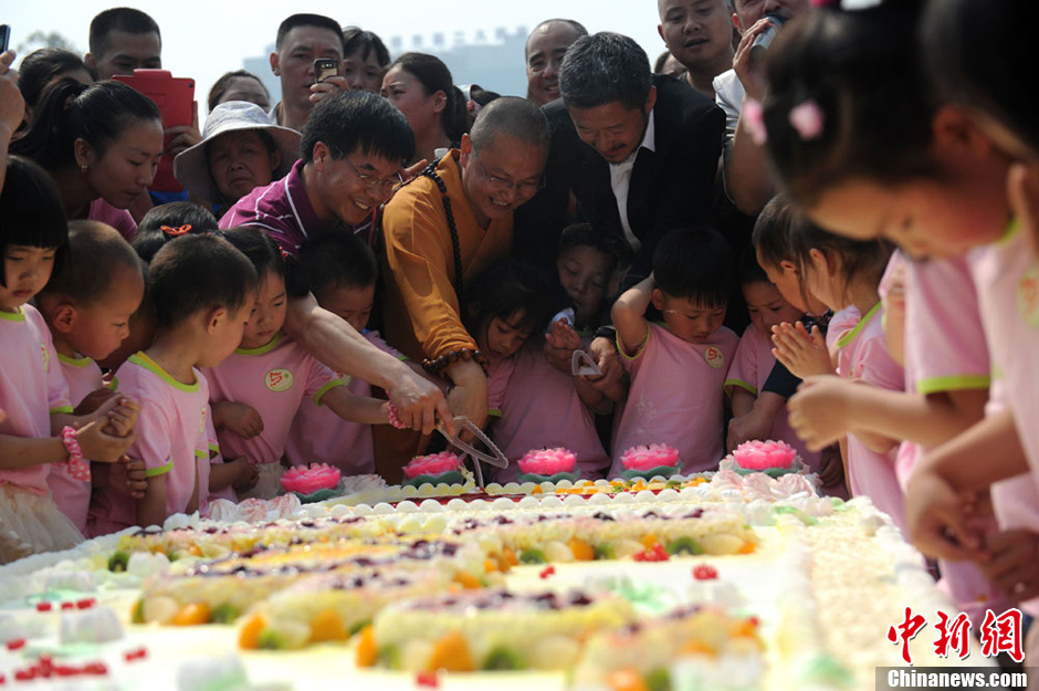 图为素全法师与影视明星吴京一起为孩子们切生日蛋糕。张浪 摄
