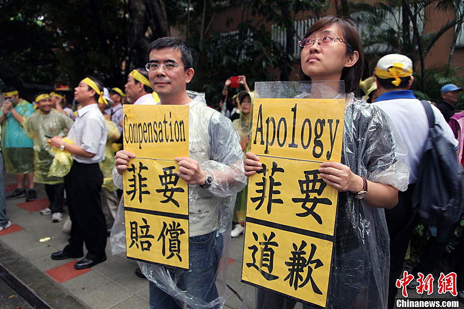 　图为当天下午，当台湾数百渔民在马尼拉经济文化办事处前抗议时，有两名年轻人手持标语，在路边声援。中新
