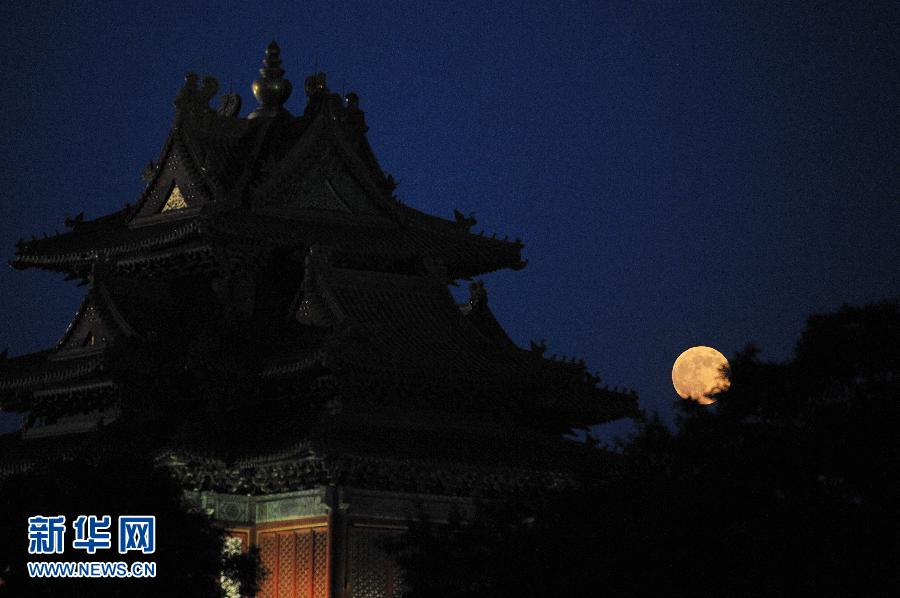 这是6月23日在北京拍摄的圆月映衬下的故宫角楼。
