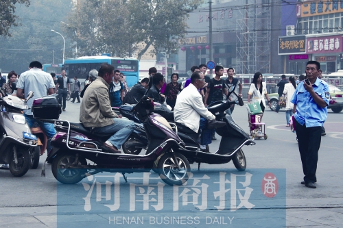 　火车站广场北侧，几辆摩的正在等客