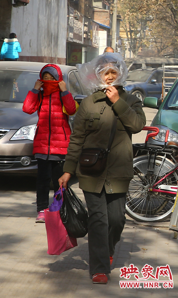 一位路人用塑料袋遮尘