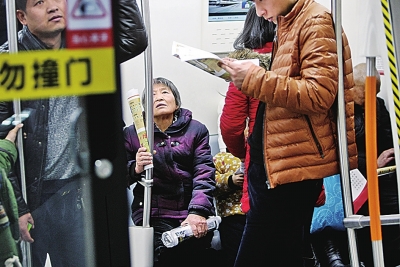 在稍显拥挤的车厢里，年轻人把座位让给老年乘客。