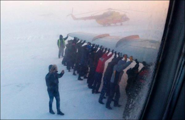 　伊加尔市一架客机起飞前被冻在了跑道上。飞机上的乘客不得不下来推飞机。