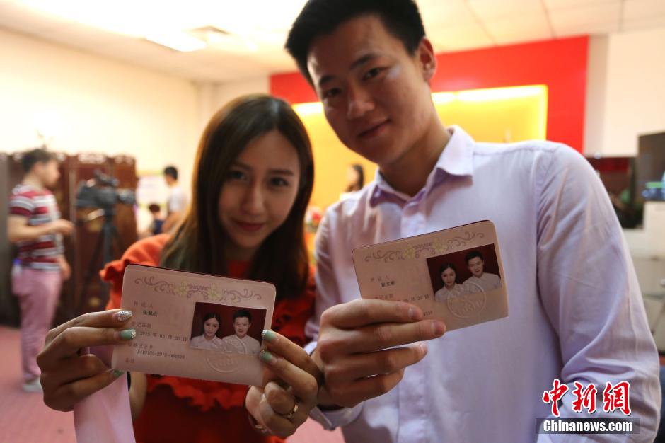 5月20日,河南郑州,一对准新人领完结婚证后秀自拍。