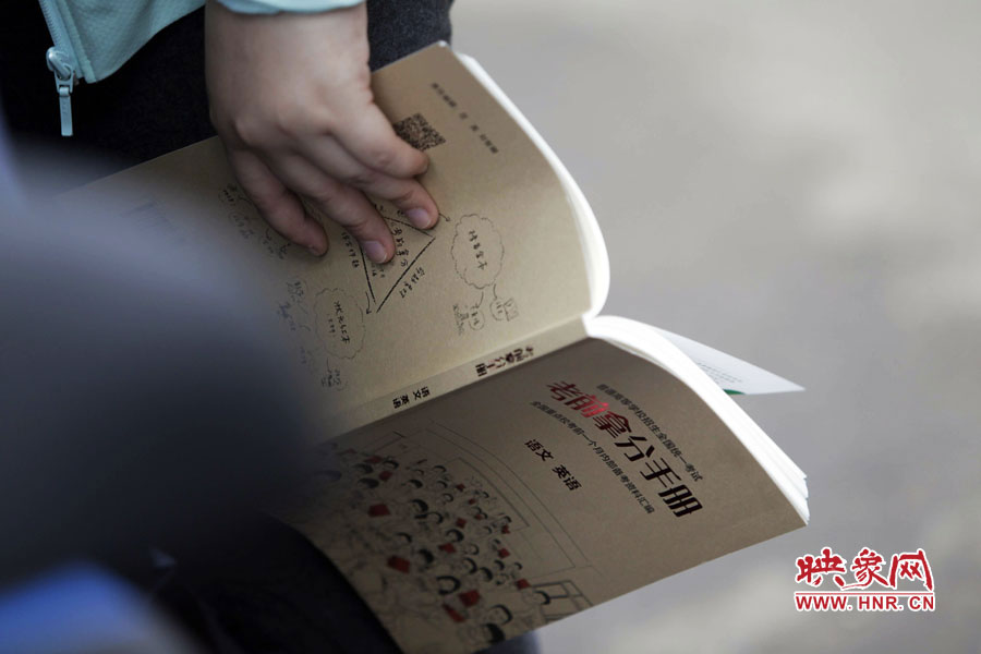 郑州回中考点,一位考生手持“考前拿分手册”。 郑州回中考点,一位考生手持“考前拿分手册”。