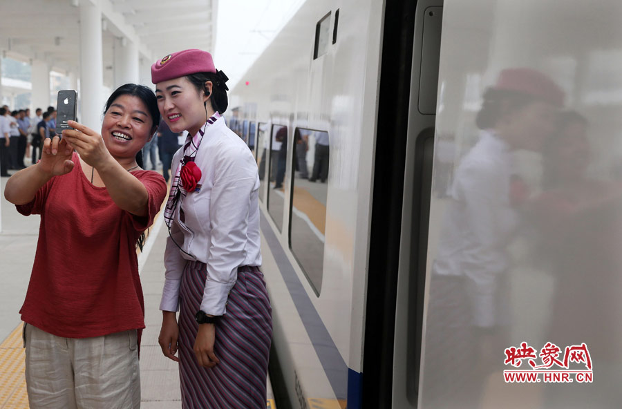 6月26日,焦作火车站。一名乘客和郑焦动车上的“动姐”自拍合影,喜不自禁
