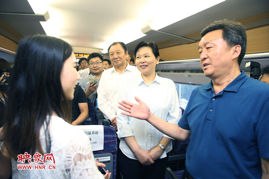 6月26日,首发的郑焦动车上,副省长王艳玲(右二)和乘客交流