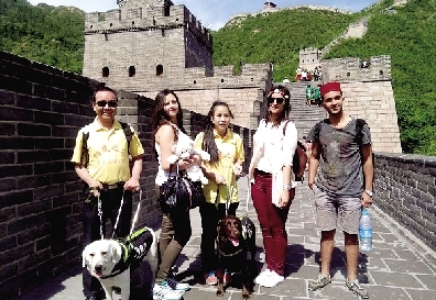 两位盲人和导盲犬在长城上与外国游客合影 受访者供图