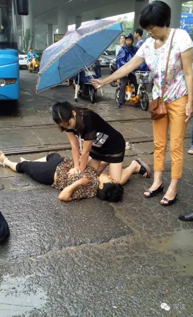 张鑫娜雨中抢救摔落的阿姨，另一位好心阿姨给她撑着伞
