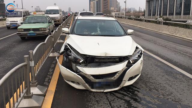 郑州私家车撞毁十米护栏　司机抽着烟逆行下桥
