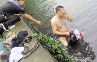 网友贴出民警张光聪一出河水就睁不开眼，用手抹去脸上脏水的照片。