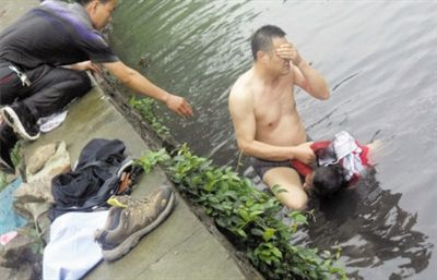 网友贴出民警张光聪一出河水就睁不开眼，用手抹去脸上脏水的照片。