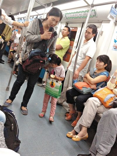 6月27日，舒馨带一女孩在地铁十号线行乞。她因被疑带多个不同小孩乞讨被警方搜寻。新京报记者 申志民 摄