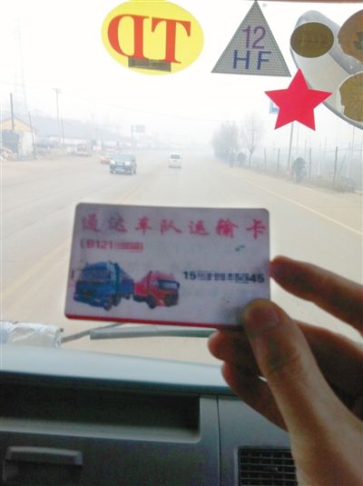 12月8日，迁西司机张田车上的“车队”联系卡，货车前风挡上，还贴有“TD”和“HF”字样的“保护牌”。他说这都是向当地“车队”购买超载“保护牌”后获得的标志，治超人员见到“保护牌”后，就会放行。