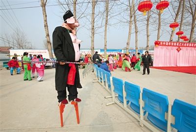 农历正月初一，顺义张镇聂庄村春节联欢会开始前，一位装扮成猪八戒的高跷演员，正在等待演出。