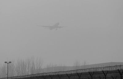 在首都机场，飞机在雾霾中降落。