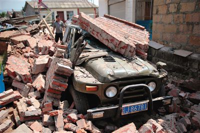 永平镇一小区围墙倒塌砸坏车辆。