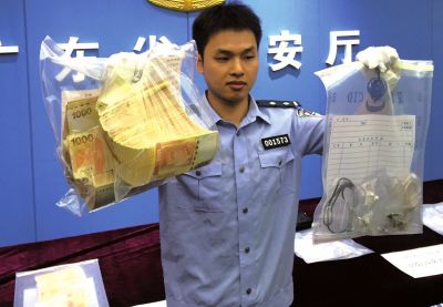 民警展示缴获的涉案赎金和赃物。新华社发 民警展示缴获的涉案赎金和赃物。新华社发