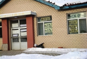 伊春市带岭区一排破旧的平房，房间窗户上贴满了“我告饶了”的字样。