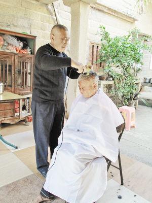 陈加兴到残疾老人家中理发。记者肖杰元摄