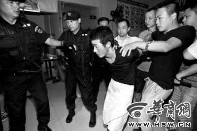 犯罪嫌疑人韩牙某围着围裙在厨房内拉面，被民警抓获 本报记者 邓小卫 摄
